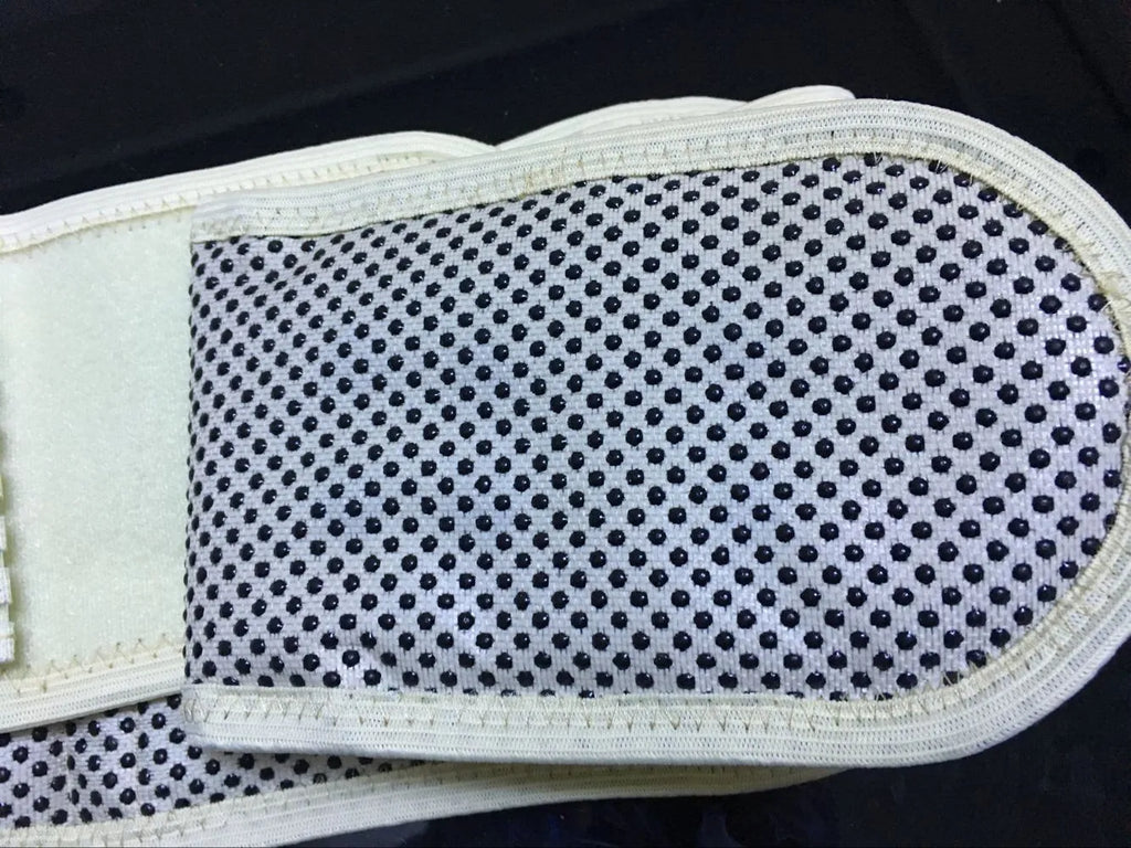 Beige self-heating lumbar support belt with magnetic therapy, shown fastened around a waist.