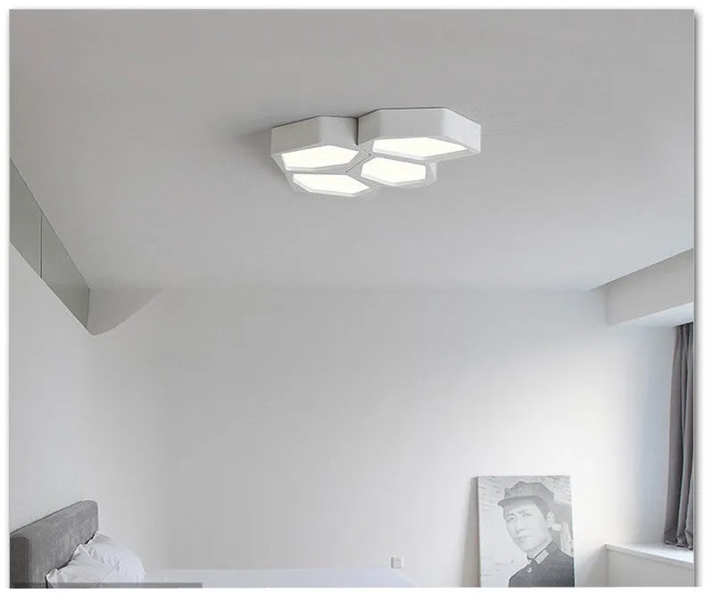 Geometric shaped iron shade LED light fixture with remote control in black or white frame.