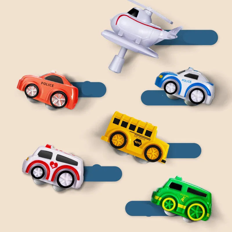 Children's plastic parking lot toy with conveyor belt, crane, and suspension bridge alongside police car and ambulance vehicles