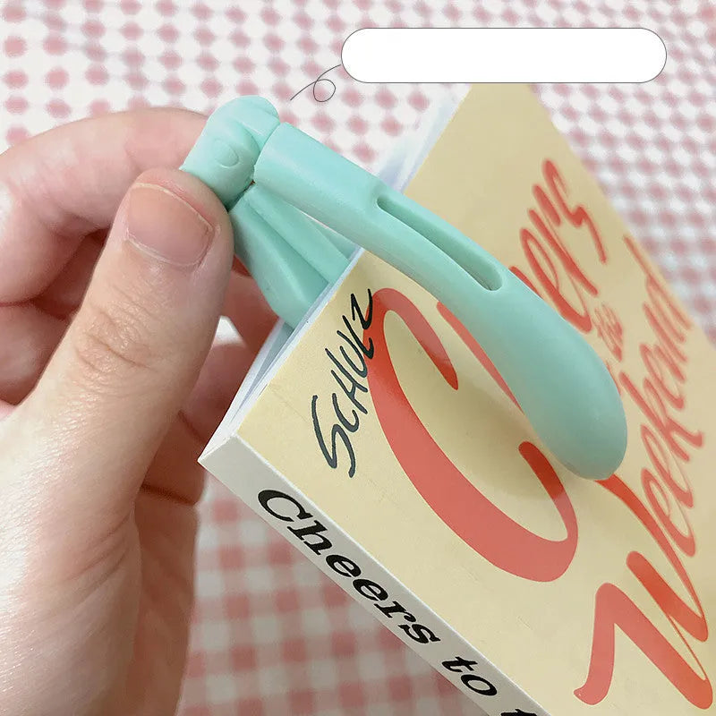 A folding book light with a clip, shown in yellow, blue, green, and pink colour options.
