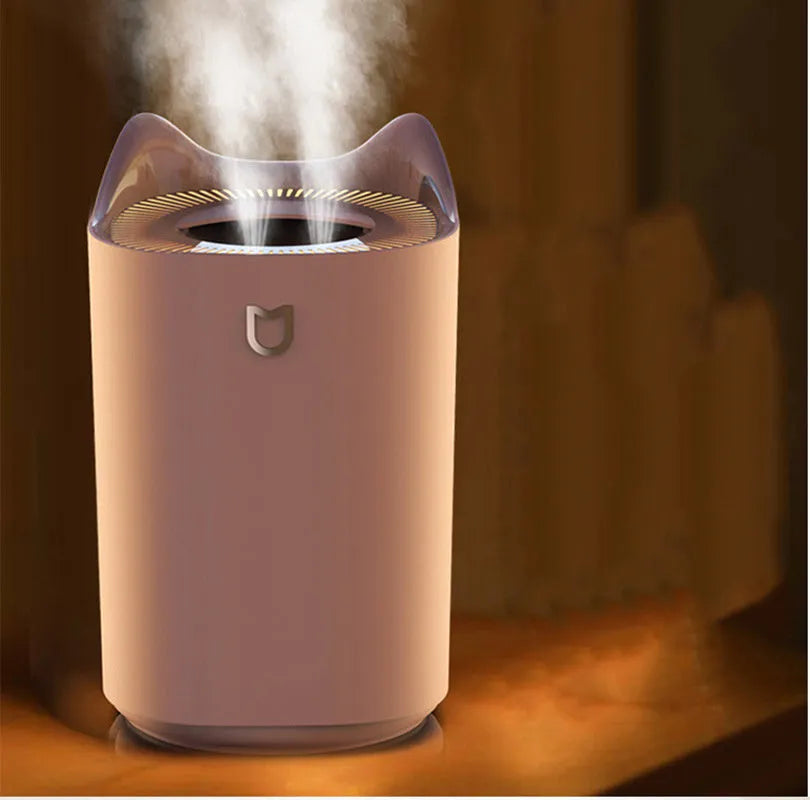 Coral Pink double spray humidifier with three mist outlets and USB cable on a wooden table.