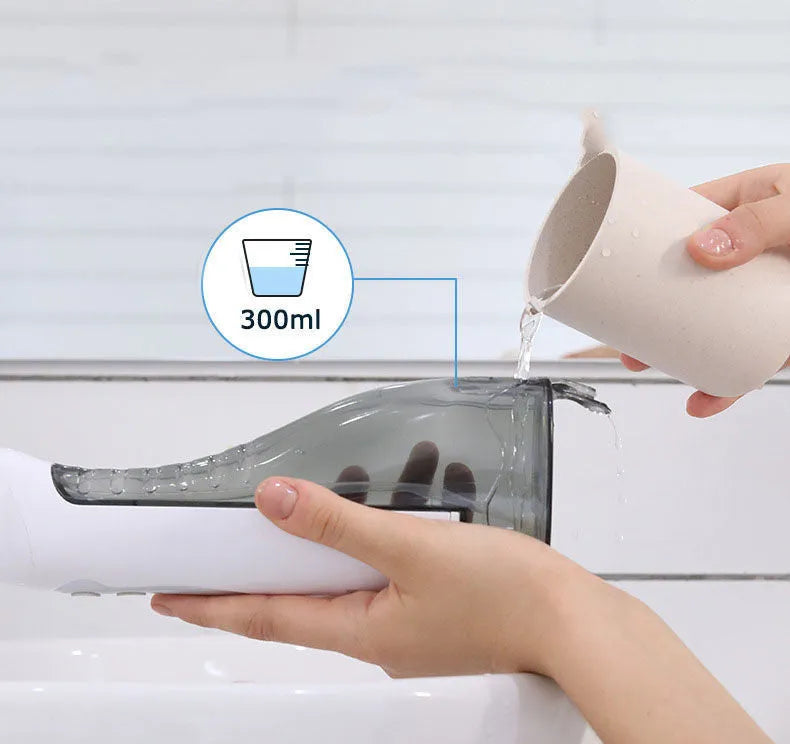 Portable white oral irrigator with large water tank, four nozzles, and a USB charging cable.