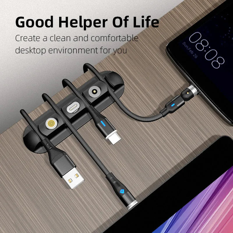 Black soft plastic desktop magnetic data cable organiser on a desk.