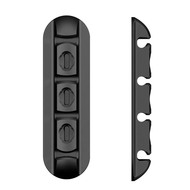 Black soft plastic desktop magnetic data cable organiser on a desk.