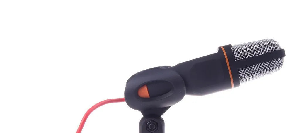 Black mini phone wired microphone with 3.5mm plug and attached adjustable holder clip on a desk.