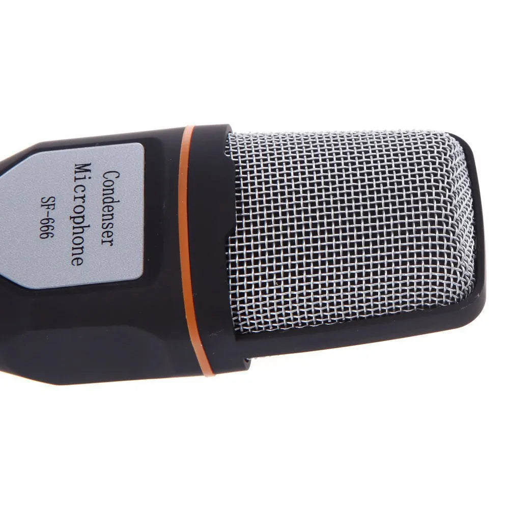 Black mini phone wired microphone with 3.5mm plug and attached adjustable holder clip on a desk.