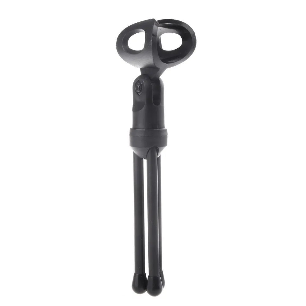 Black mini phone wired microphone with 3.5mm plug and attached adjustable holder clip on a desk.