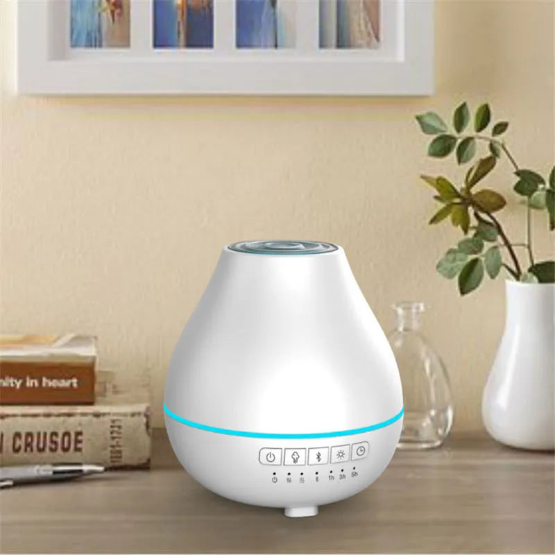 White round Bluetooth humidifier and essential oil diffuser with LED night light on a wooden surface.