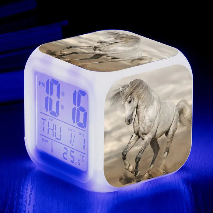 Small square cartoon LED alarm clock with colour-changing face showing digital time and temperature.