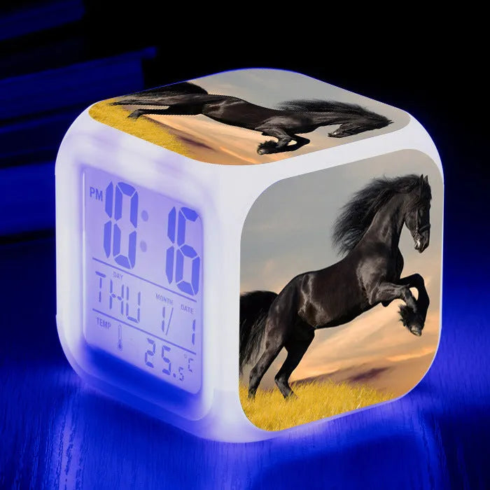 Small square cartoon LED alarm clock with colour-changing face showing digital time and temperature.