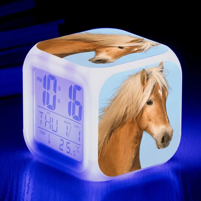 Small square cartoon LED alarm clock with colour-changing face showing digital time and temperature.