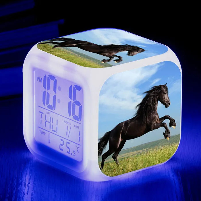 Small square cartoon LED alarm clock with colour-changing face showing digital time and temperature.