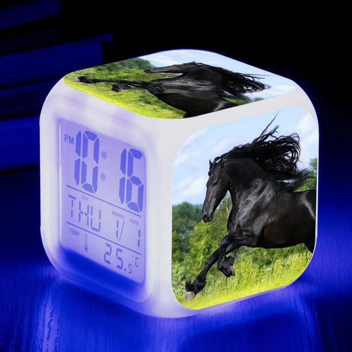 Small square cartoon LED alarm clock with colour-changing face showing digital time and temperature.