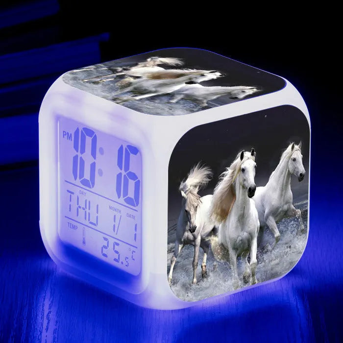 Small square cartoon LED alarm clock with colour-changing face showing digital time and temperature.