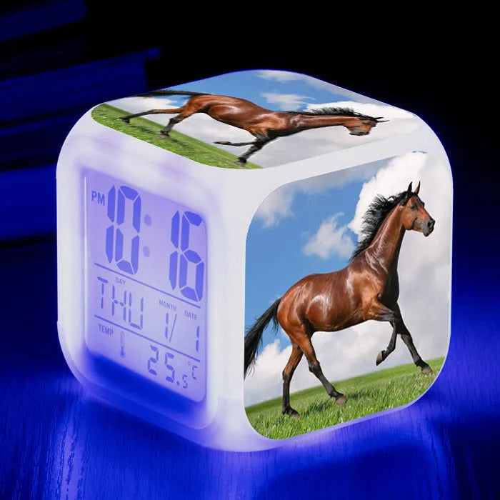 Small square cartoon LED alarm clock with colour-changing face showing digital time and temperature.
