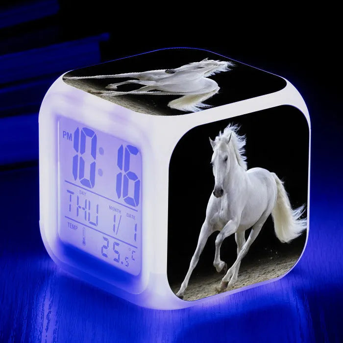 Small square cartoon LED alarm clock with colour-changing face showing digital time and temperature.