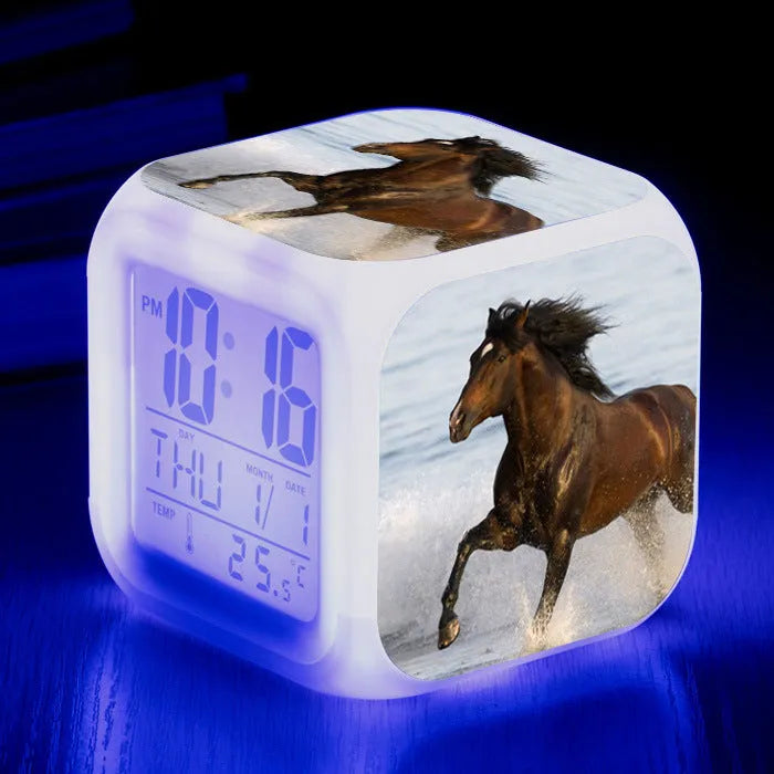 Small square cartoon LED alarm clock with colour-changing face showing digital time and temperature.