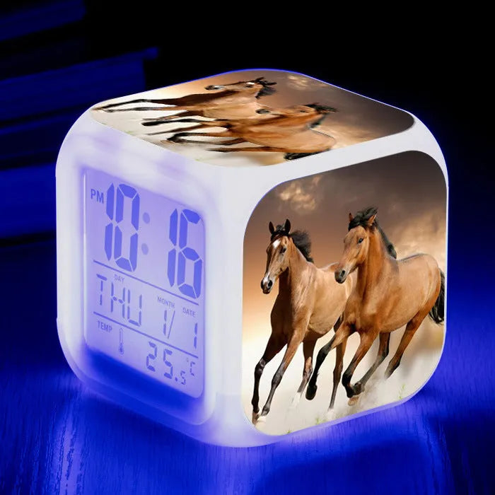 Small square cartoon LED alarm clock with colour-changing face showing digital time and temperature.