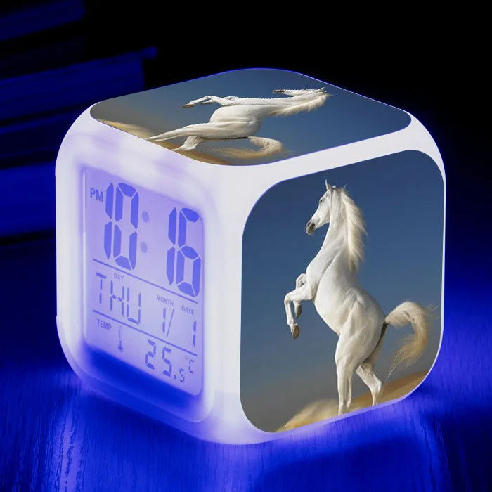 Small square cartoon LED alarm clock with colour-changing face showing digital time and temperature.