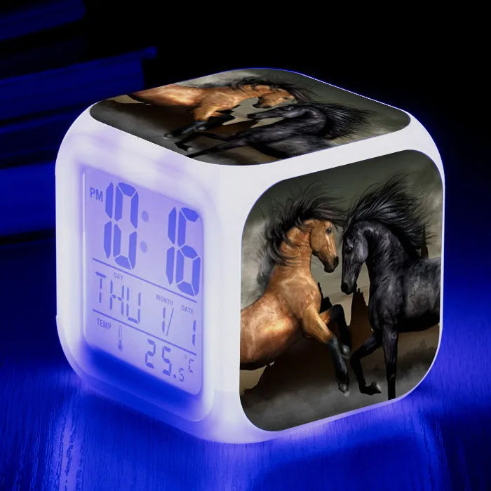 Small square cartoon LED alarm clock with colour-changing face showing digital time and temperature.