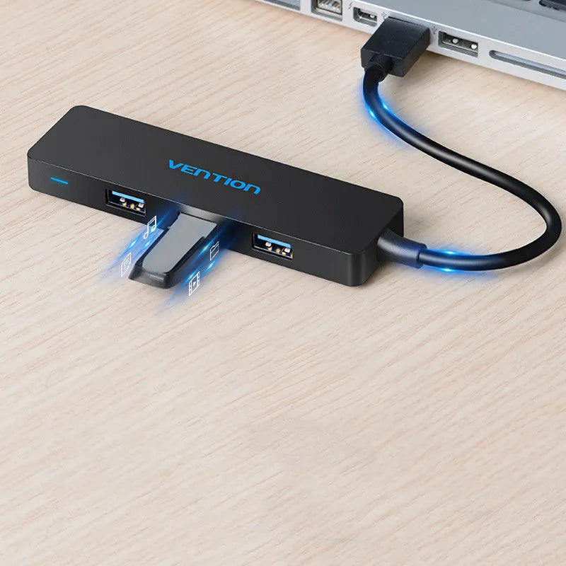 Black four-port USB 3.0 hub with a short connected cable on a desk