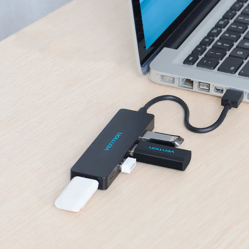 Black four-port USB 3.0 hub with a short connected cable on a desk