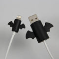 White angel and black bat style silicone protective covers for mobile phone charging cables.