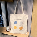 Medium orange canvas tote bag with geometric print, showing zipper opening and internal phone pocket.
