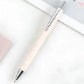 Metal push ballpoint pen with sequin finish in black colour on white background