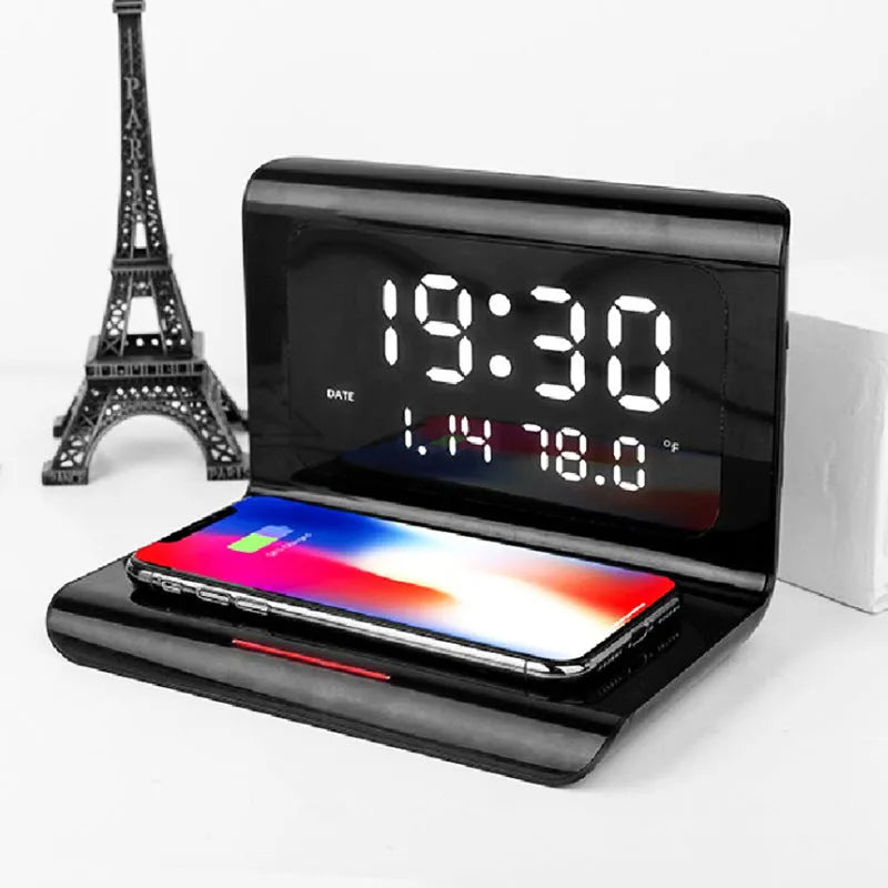 White wireless charger alarm clock showing time, date, and temperature on its display with a phone charging on top.