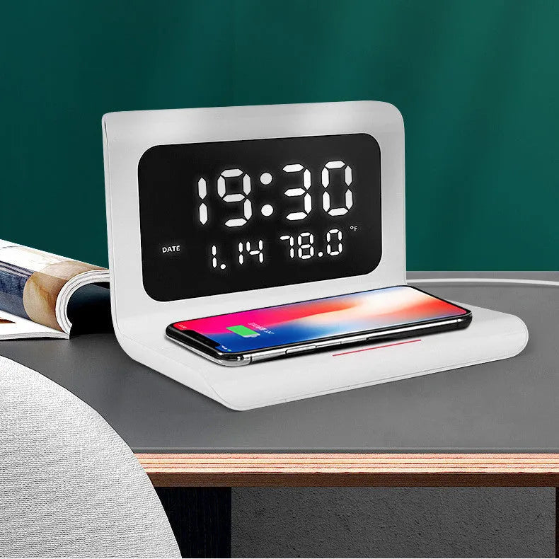 White wireless charger alarm clock showing time, date, and temperature on its display with a phone charging on top.