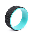 Massage point yoga wheel in black on floor with raised texture surface for backbending and Pilates muscle relaxation