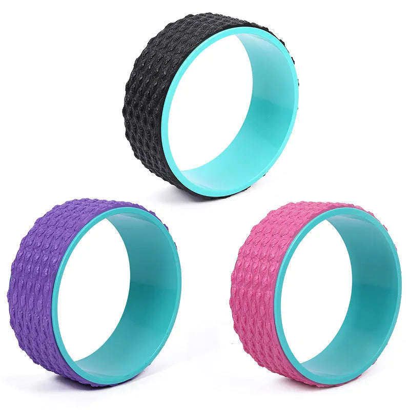 Massage point yoga wheel in black on floor with raised texture surface for backbending and Pilates muscle relaxation