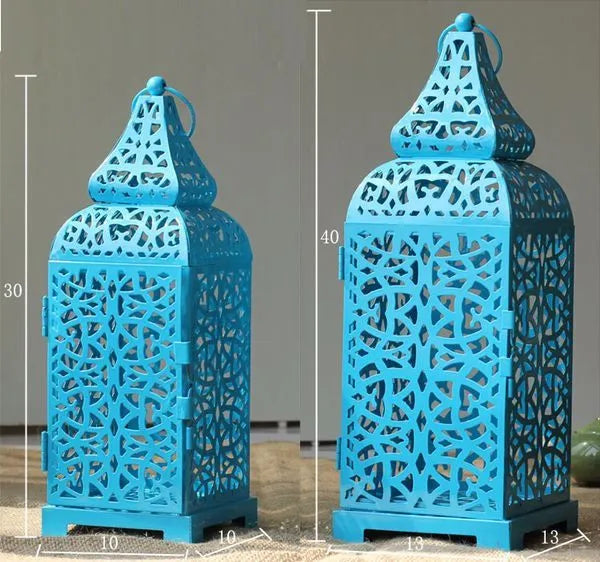 Pair of blue geometric metal wall sconces with tea light, showing Moroccan-style openwork design.