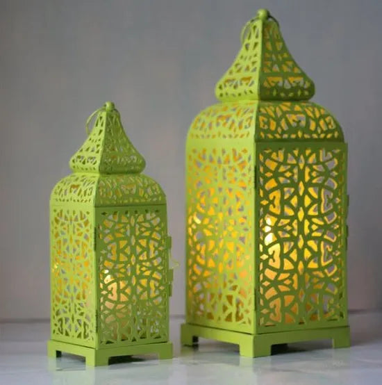 Pair of blue geometric metal wall sconces with tea light, showing Moroccan-style openwork design.