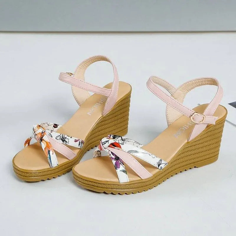 Women's pink wedge sandals with a thick heel and fish mouth design, featuring a buckle closure.