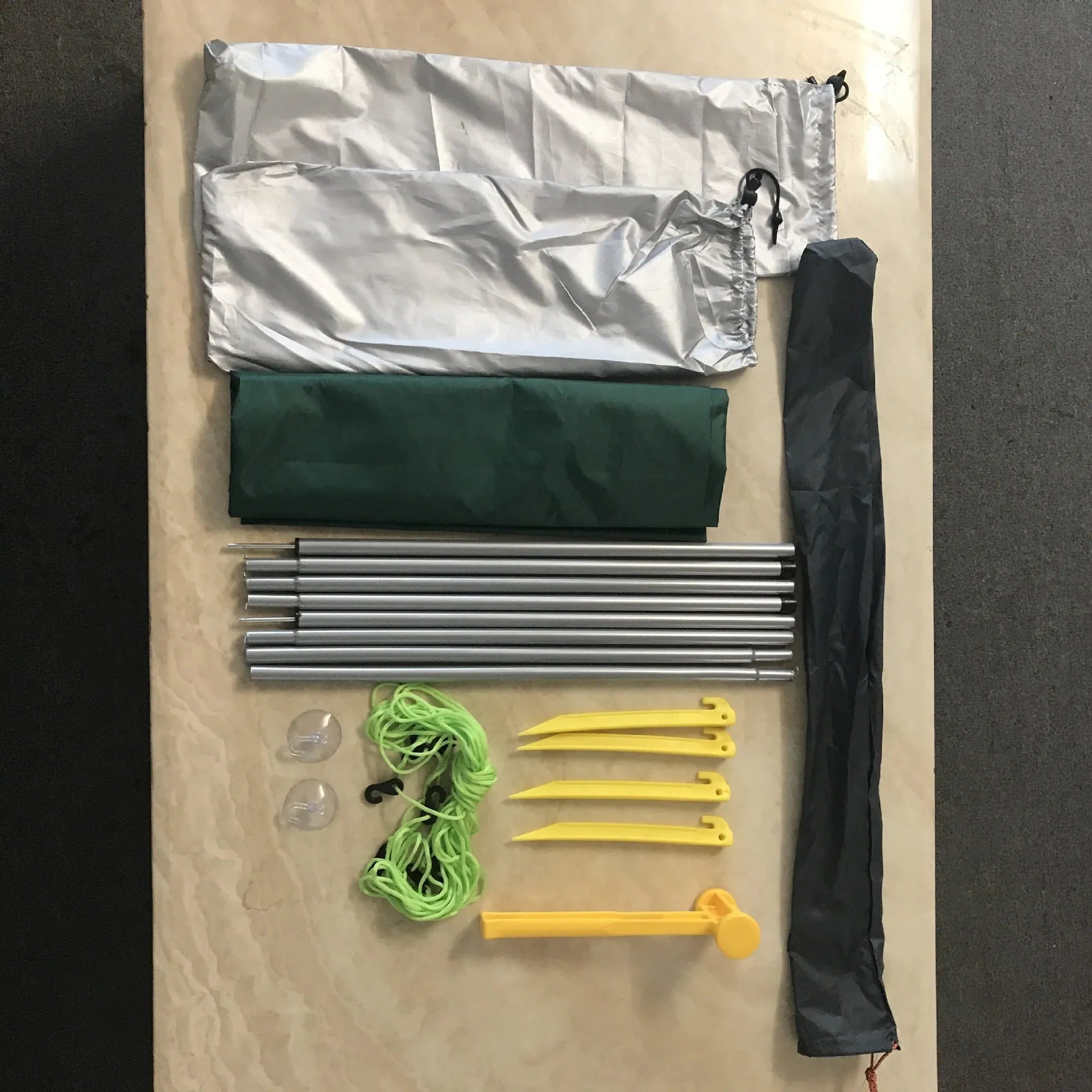 Green double tent car side awning with aluminium pole setup outdoors