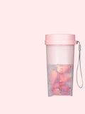 Portable pink and green rechargeable electric juicer cup with USB charging cable.
