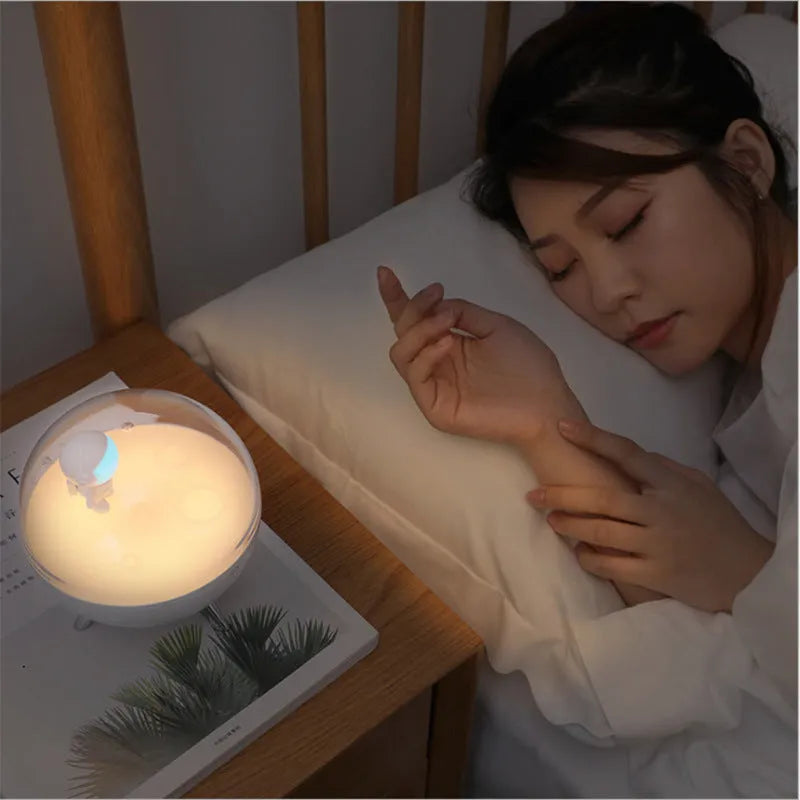 USB-powered cartoon-style LED night light showing white and blue colour options on a desk.