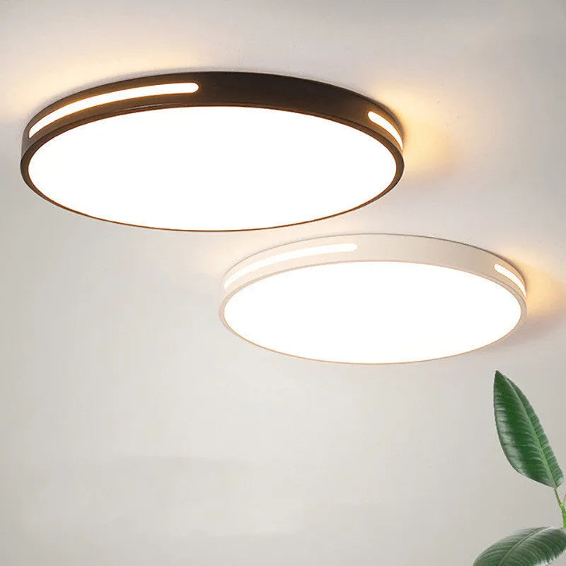 Round white acrylic remote control LED ceiling lamp mounted on a bedroom ceiling.