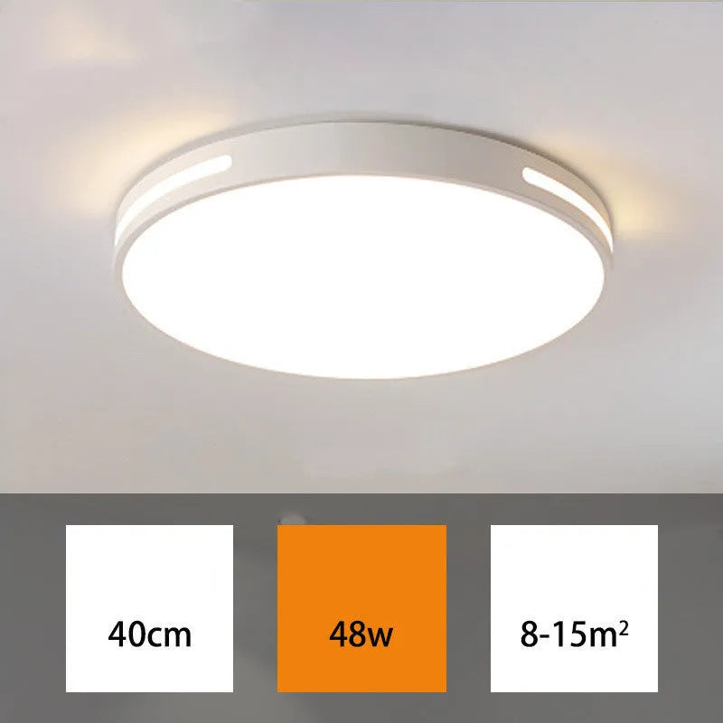 Round white acrylic remote control LED ceiling lamp mounted on a bedroom ceiling.