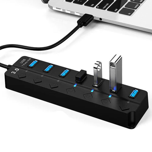 Black 7-port USB 3.0 hub with external power adapter and 1-metre cable on a desk