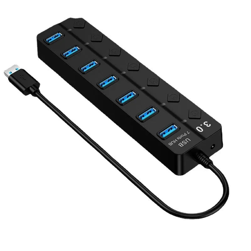 Black 7-port USB 3.0 hub with external power adapter and 1-metre cable on a desk