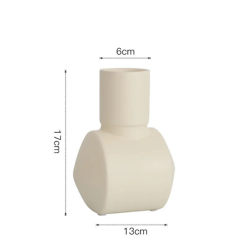 Morandi coloured ceramic vase with hammered glaze texture on a wooden shelf.