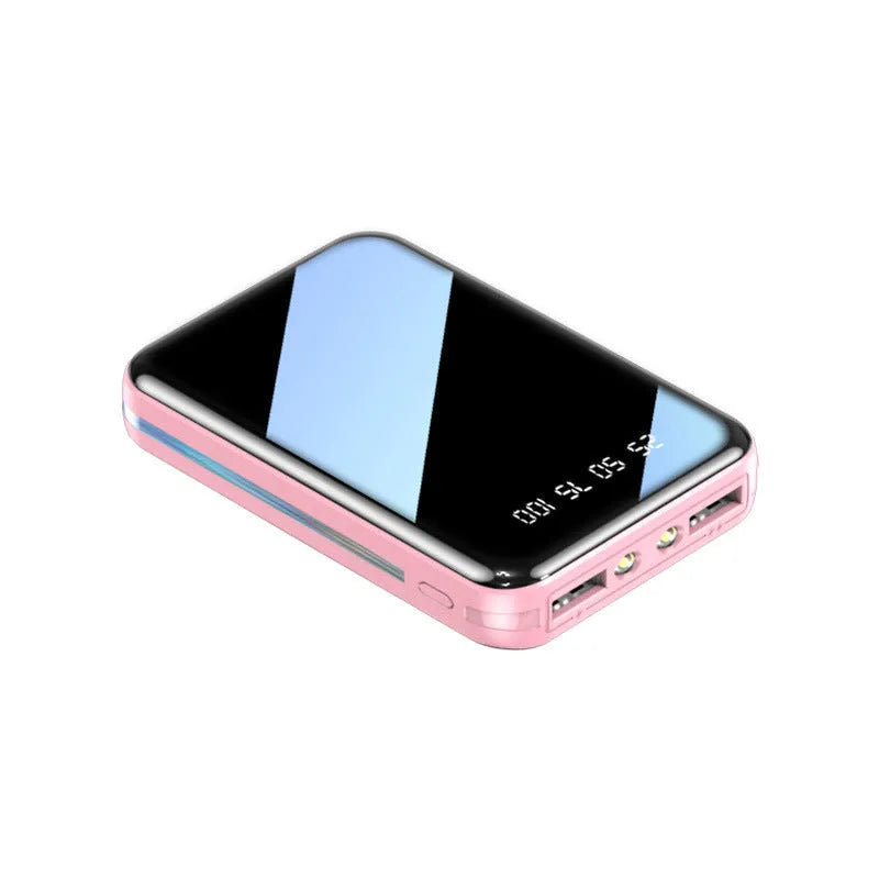 Compact white power bank with digital display showing battery percentage, next to a smartphone.
