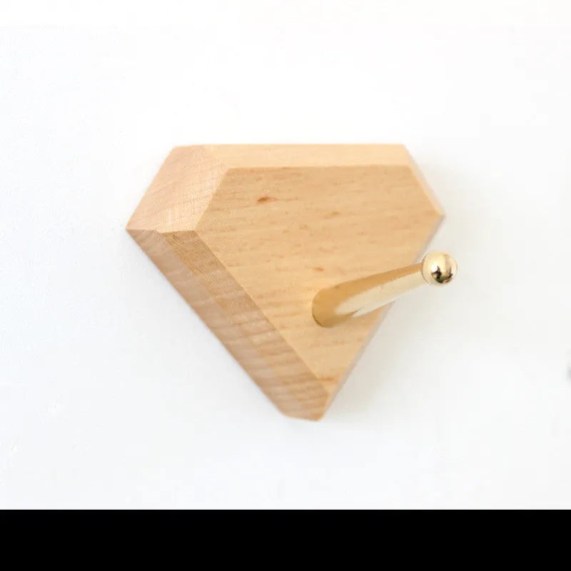 Beech wood wall hook with brass mechanism in five shapes: round, capsule, oval, diamond, and square