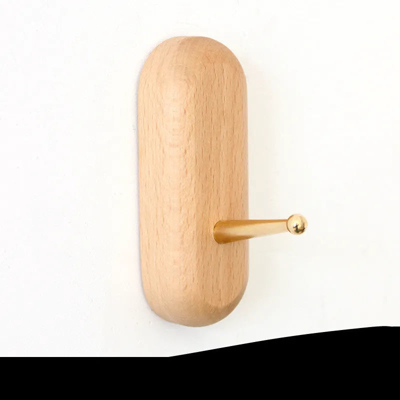 Beech wood wall hook with brass mechanism in five shapes: round, capsule, oval, diamond, and square