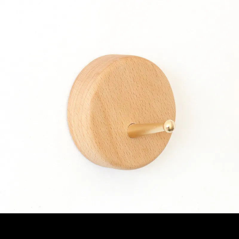 Beech wood wall hook with brass mechanism in five shapes: round, capsule, oval, diamond, and square