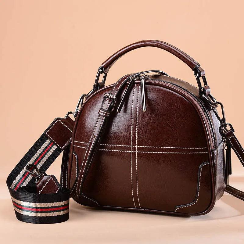 A simple round leather handbag with a soft handle and double straps, shown in a choice of colours.