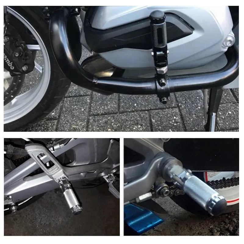 Two black aluminium alloy round folding motorcycle foot pedals on a workbench